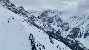 Dağ aralığının hava drone görüntüsü. Bakire beyaz karla kaplı. Kazakistan 'ın Almaty şehrindeki Tien Shan Dağı