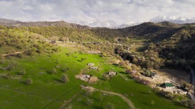 Dağ vadisi tarlasının hava aracı manzarası ilkbahar ağaçları ve Kazakistan yakınlarındaki köy manzarası.