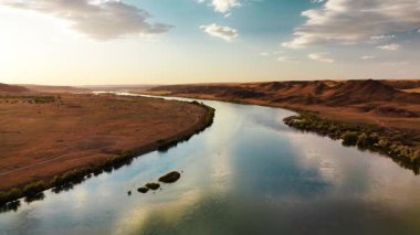 Ili Nehri ve bahar bozkırlarının hava görüntüsü Kazakistan 'da günbatımında bulutlu gökyüzü