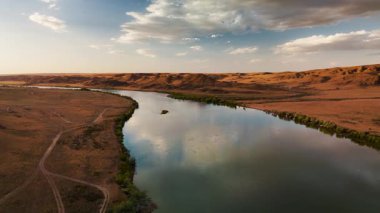 Ili Nehri ve bahar bozkırlarının hava görüntüsü Kazakistan 'da günbatımında bulutlu gökyüzü