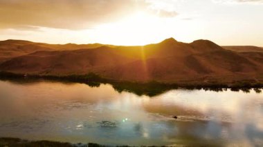 Ili Nehri 'nin ve bahar bozkırının hava görüntüsü. Güneş batarken sarı gökyüzü ve Kazakistan' da yağmur damlaları.