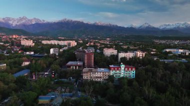 Hava aracı manzaralı geniş yol manzaralı trafik ve büyük evler, otel, günbatımında gökyüzü arka planında binalar Almaty City, Kazakistan 'da.