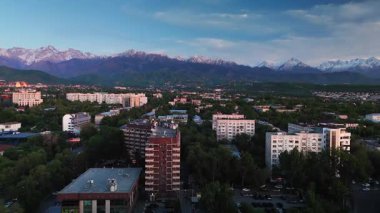 Hava aracı manzaralı geniş yol manzaralı trafik ve büyük evler, otel, günbatımında gökyüzü arka planında binalar Almaty City, Kazakistan 'da.