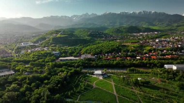 Yeşil Park Hill Vadisi 'ndeki evlerin hava aracı manzarası. Kar dağlarının manzarası. Almaty City, Kazakistan' daki mavi gökyüzü arka planı.