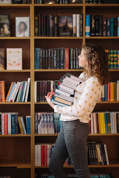 Teen Girl Pile Books Young Girl Holding Books Shelves Background — стоковое фото