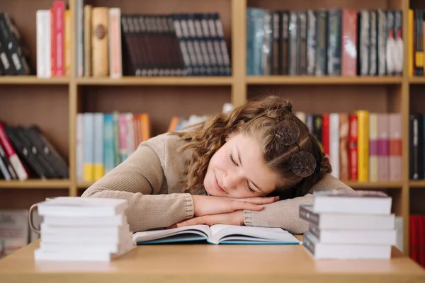 勉強中に若い女性が本の上で寝て頭の上に眼鏡をかけて — ストック写真