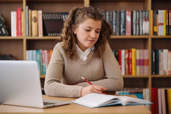 Çekici Mutlu Genç Kız Öğrenci Üniversite Kütüphanesinde Okuyor Masada Oturuyor — Stok fotoğraf