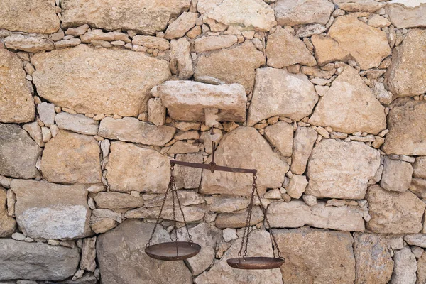 Old scales of justice on a Real stone wall surface background