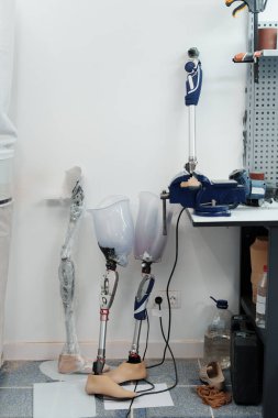Ortopedik ekipman atölyesinde duvara dayanan dört adet protez bacak, engelli konsepti
