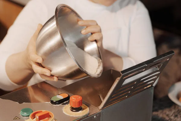 レストランキッチンでおいしいディナーを準備しながら パスタメーカーに金属ボウルから小麦粉を注ぐミステリー匿名の女性料理 — ストック写真
