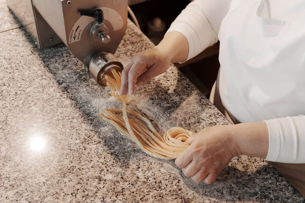 伝統的なイタリアのロール新鮮なTagliatelleパスタを調理するミステリー匿名の女性の料理はキッチンで大理石のカウンターで — ストック写真