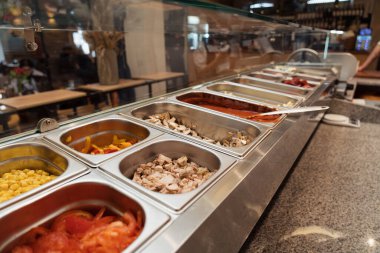 Geleneksel pizzacının mutfağında sıraya dizilmiş metal kaplarda çeşitli malzemeler. Yüksek kalite fotoğraf