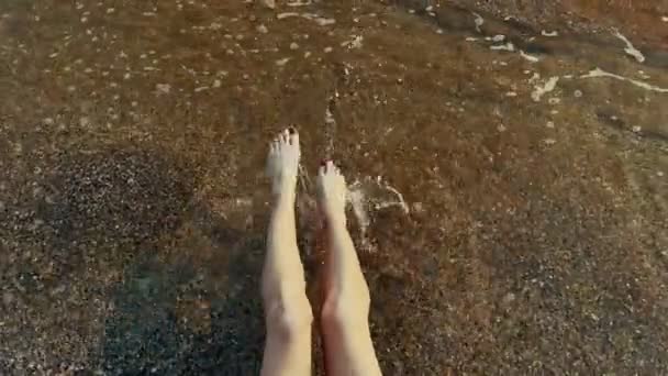 여자가 바위가 해변에서 튀기고 있습니다 다리의 바라본다 고품질 — 비디오