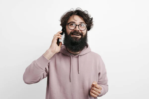 Веселый Молодой Человек Бородой Разговаривает Мобильным Телефоном Белой Стены — стоковое фото