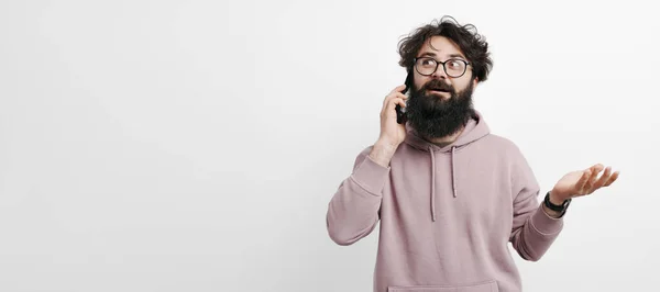Wesoły Młodzieniec Brodą Rozmawiający Telefonem Komórkowym Białej Ścianie — Zdjęcie stockowe