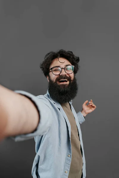 Радостный Бородатый Мужчина Очках Джинсовой Рубашке Делает Селфи Сером Фоне — стоковое фото