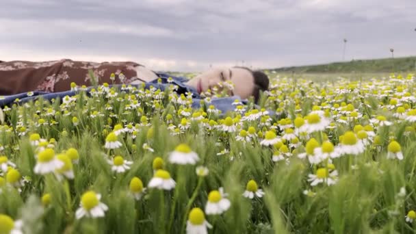 Piękna Młoda Kobieta Leży Polu Rumianku Zbliżenie Chmurny Letni Dzień — Wideo stockowe