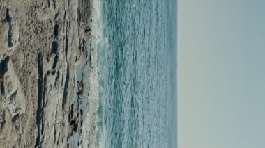 Akdeniz 'in kayalık kıyılarına yavaş çekim dalgaları sıçrıyor. Dikey video