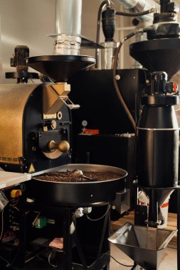 Modern endüstriyel fabrikada kahve çekirdeklerini kızartıp karıştıran profesyonel bir makine.