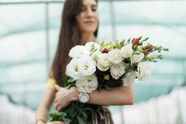 Close up fresh beautiful flowers bouquet in women hands. Flower harvesting.