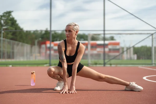 Een Sportieve Vrouw Met Kort Blond Haar Strekt Zich Uit — Stockfoto