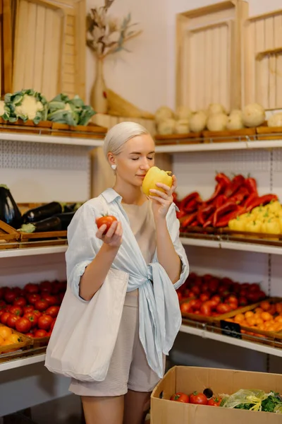 Kobieta Luźnym Stroju Trzymająca Żółtą Paprykę Pomidora Zastanawia Się Czy — Zdjęcie stockowe