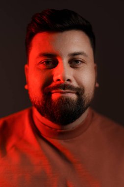 Sıcak tonlarda bir adamın hafif ışıklı portresi, nazik, çekici bir bakış sunuyor.