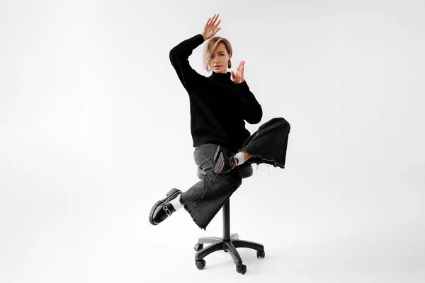 Fashionable Young Woman Striking Dynamic Pose Chair Black Outfit Bold — Stock Photo, Image