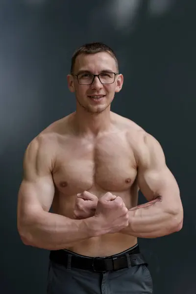 A muscular man with eyeglasses confidently flexes, a symbol of brain and brawn