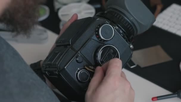 Ένας Εστιασμένος Άνθρωπος Εξετάζει Μια Κάμερα Μεσαίου Σχήματος Βυθισμένος Στην — Αρχείο Βίντεο