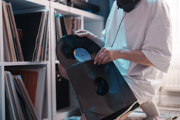 A person selects a vinyl record from a collection, showcasing music appreciation.