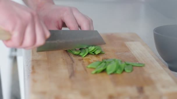 건강한 요리와 준비를 설정에서 나무로 보드에 신선한 완두콩을 자르는 클로즈업 — 비디오