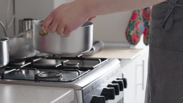 一个人在厨房里做饭 站在一个装有锅和锅的煤气炉前的特写画面 重点放在手头上 传达一种做家务和做饭的感觉 — 图库视频影像