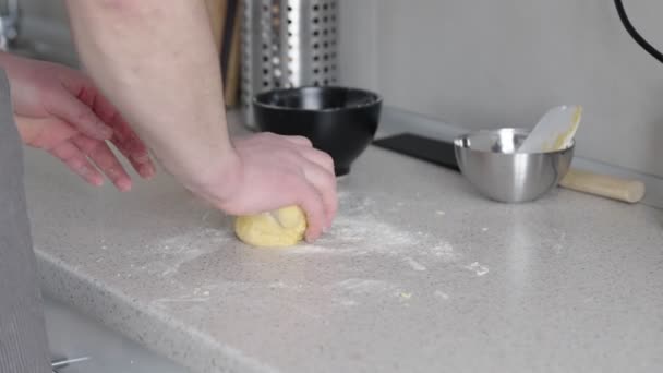 在厨房柜台上准备面团的人 用手在新鲜的圆面团上撒些面粉 旁边坐着一个滚动的别针和金属碗 捕捉了家庭烘烤和烹调准备的精髓 — 图库视频影像