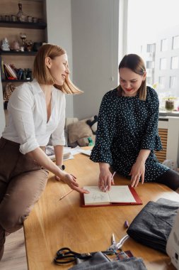 Evde iki kadının tasarım planını tartıştığı sıradan bir iş görüşmesi. Samimi bir ortamda takım çalışması ve yaratıcılık hissi..