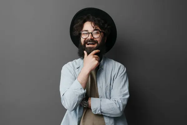 안경과 세련된 모자를 수염된 남자의 초상화 자신감으로 스튜디오 배경에 손으로 스톡 사진
