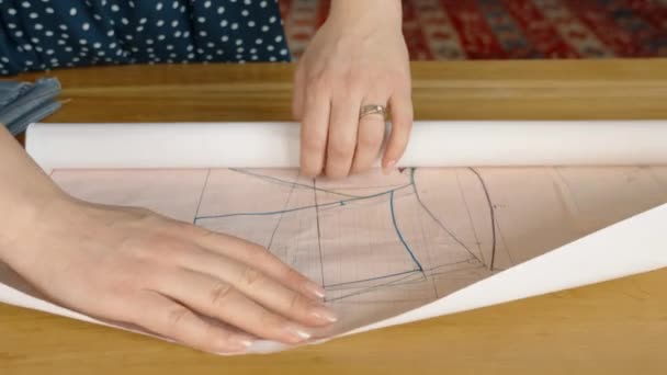 Bir Kadın Terzinin Ahşap Bir Masanın Üzerindeki Kağıt Desenlerini Açıp — Stok video