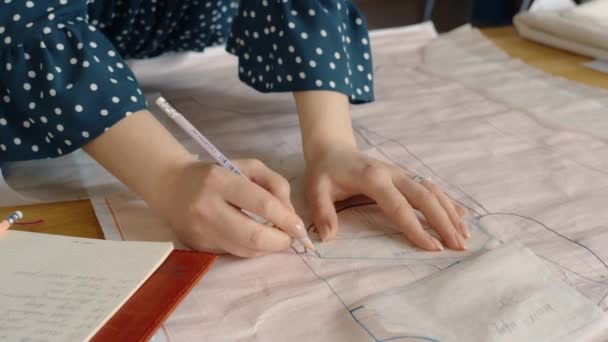 一位女性时装设计师在追踪纸上手工追踪缝纫图案 构思新服装设计的特写 — 图库视频影像