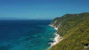 Sersemletici hava manzarası yoğun, yeşil bir kıyı şeridi boyunca uzanan canlı mavi suları yakalıyor. Üzerimizde berrak bir gökyüzü var. Huzur hissi uyandırıyor..