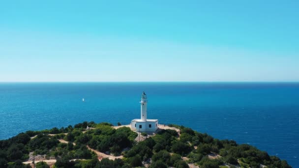 一片宁静的海景 头顶上有一座白色的灯塔 四周环绕着茂盛的绿叶 蓝蓝的大海笼罩在晴朗的天空之下 — 图库视频影像