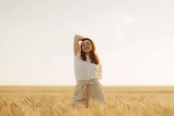 Ευτυχισμένη Νεαρή Γυναίκα Λευκό Πουκάμισο Στέκεται Ένα Χωράφι Σιτάρι Ηλιοβασίλεμα Εικόνα Αρχείου