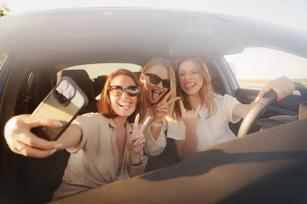 Három Örömteli Együtt Fotózza Szelfit Miközben Egy Autóban Ülnek Boldogságot Stock Kép