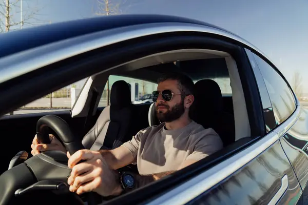 Άνθρωπος Γυαλιά Ηλίου Που Οδηγεί Ηλεκτρικό Αυτοκίνητο Επιδεικνύοντας Έναν Βιώσιμο Εικόνα Αρχείου