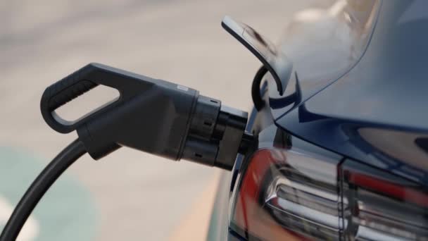 Nærbillede Elektrisk Biloplader Tilsluttet Skinnende Blå Bil Fremvisning Miljøvenlig Transport – Stock-video