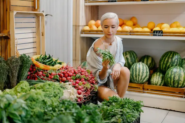 Young Woman Short Hair Examining Bunch Greens While Shopping Fresh Rechtenvrije Stockafbeeldingen