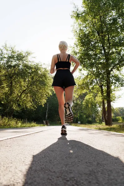 Молода Жінка Спортсменка Біжить Сонячному Світлому Шляху Оточеному Деревами Демонструючи Ліцензійні Стокові Зображення