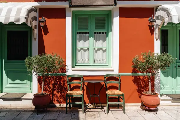 Elegante Outdoor Cafe Tegen Een Levendige Oranje Muur Met Vintage Rechtenvrije Stockfoto's