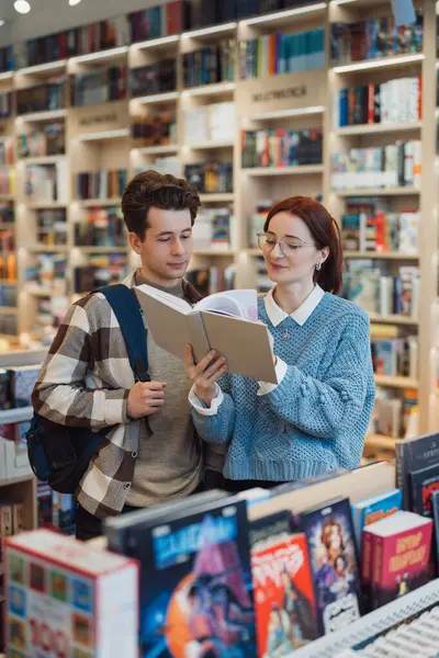 Young Man Woman Closely Examining Book Together Well Stocked Contemporary Stock Image