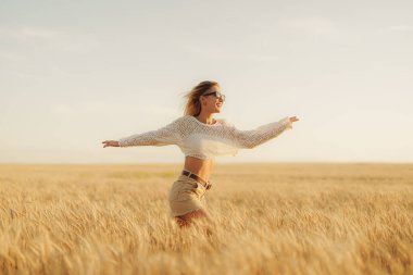 Gün batımında bir buğday tarlasında kollarını açmış kaygısız genç bir kadın, özgürlüğün, neşenin ve doğanın vücut bulmuş halidir..