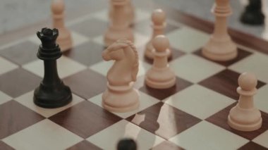 Siyah vezir ve beyaz şövalye satranç taşlarına odaklı satranç tahtasını kapat. Stratejik oyun, rekabet, turnuva kavramları.